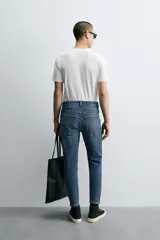 Pantalón de jean color beige, corte skinny, tiro medio, largo cropped y cinco bolsillos.
