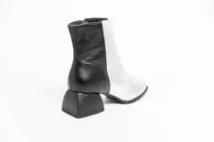 Botas cortas de cuero plateado y negro con punta cuadrada y taco geométrico.