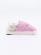 Pantuflas tipo slip-on, color rosado, con capellada acolchada y forro interior de pelo sintético color crema. Suela blanca de goma.