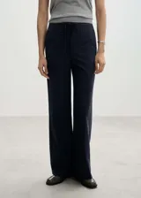Pantalón de vestir azul marino con finas rayas verticales blancas, corte recto, tiro medio, lazo a la cintura y cierre de gancho y cremallera.