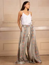 Pantalón palazzo marrón con bordados de estilo étnico en colores azul, naranja y rosa. Tiene cintura elástica con cordón ajustable y bolsillos laterales.
