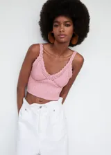 Top crop de punto color rosa, con cuello en V y tirantes finos. Tejido de algodón con detalle calado en el escote. Diseño entallado.