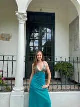 Vestido largo negro con escote en V, cut outs laterales bajo el busto y breteles finos cruzados y atados en la espalda.