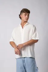 Camisa de lino color blanco, de manga corta, con cuello clásico y cierre frontal con botones.