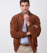 Campera estilo bomber color marrón, unisex, confeccionada en cuero tipo antílope, con cierre frontal y bolsillos laterales.
