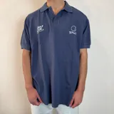 Chomba azul con cuello clásico, corte oversize, manga corta y estampado con motivos de golf.