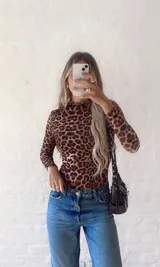 Top de microtul con estampado animal print de leopardo, doble tela, cuello alto y mangas largas.