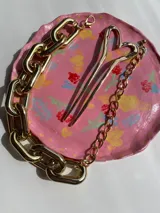 Collar dorado tipo cadena con eslabones grandes rectangulares.