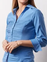 Camisa blanca de algodón marca Zac & Rachel, con cuello con solapa, abertura central con botones, delantera tableada y laterales elastizados.