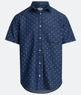 Camisa de manga corta azul con estampado de círculos blancos, cuello camisero, abotonada al frente y con bolsillo en el pecho.