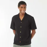Camisa negra de manga corta con cuello solapa y cierre frontal con botones de madera.