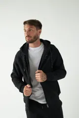 Campera de felpa color bordó con capucha y cordón ajustable, cierre frontal con cremallera, bolsillos laterales y logo estampado en el pecho.