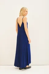 Vestido largo plisado color azul eléctrico, con breteles regulables, escote redondo en el frente y espalda baja. Confeccionado en viscosa con hilos de lurex a tono y moldería amplia.