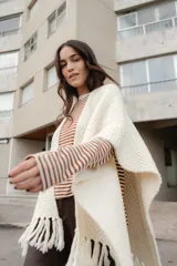 Ruana tejida en lana merino color amarillo pastel, con terminación de flecos.