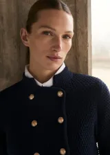 Chaqueta azul marino de punto medio con cuello mao, cierre de doble botonadura con botones dorados efecto joya y diseño recto.