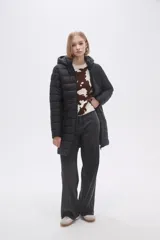Campera negra larga con capucha, de poliamida con relleno y diseño acolchado horizontal.