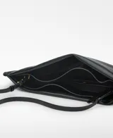 Bolso de mano rectangular color naranja brillante, con asa de mano y asa larga regulable extraíble. Tiene un compartimento con cierre magnético y logo grabado.