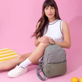 Mochila color beige de nylon resistente, con cierre principal y bolsillo frontal. Cuenta con detalle en simil cuero y bolsillo pequeño. Bolsillo trasero con cierre y bolsillos laterales para mayor comodidad. Correas a tono.