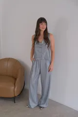 Conjunto de dos piezas color azul eléctrico, compuesto por un chaleco de manga corta con escote en V y botones frontales, y un pantalón de tiro alto con pierna ancha y pliegues.