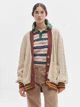 Remera polo de manga larga con rayas horizontales en blanco, rojo y verde. Cuello camisero rojo con cierre de dos botones y logo bordado en el pecho.