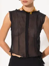 Top negro traslúcido sin mangas con cuello redondo y detalle de volados en los bordes.