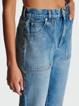 Pantalón de jean Balmain de tiro alto, corte acampanado, bolsillos frontales y traseros, y cierre con botón y cremallera.