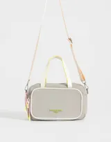 Cartera bowling gris claro de tela deportiva con bolsillo frontal y tag de goma. Tiene correa regulable desmontable, manijas superiores, cierre superior, bolsillo frontal con cierre y puller de cordón y goma, y mosquetón lateral con cordones decorativos.