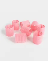 Set de ocho ruleros rosados con superficie de velcro para sujetar el pelo.