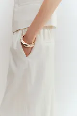 Pantalón culotte color blanco hueso, de tiro alto con cintura elástica, corte amplio y bolsillos laterales.