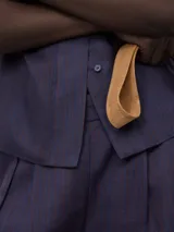 Camisa azul de ramio con cuello chimenea, manga corta con vuelta y botonadura frontal oculta.
