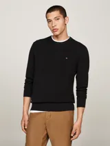 Sweater negro de punto texturizado de algodón, con cuello redondo, puños y bajo de punto canalé. Logo de Tommy Hilfiger bordado en el pecho.
