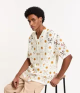 Camisa masculina de corte boxy, color crudo con diseño calado de ganchillo y girasoles color mostaza.
