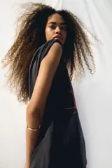 Remera negra de algodón con estampado del logo de la banda The Cure en tonos rosa y naranja. Corte oversized, cuello redondo y mangas cortas.