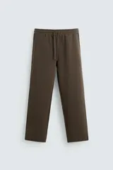 Pantalón de jogging marrón, corte recto, con cintura elástica ajustable con cordón, bolsillos frontales y traseros.