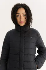 Campera puffer negra de Levi's con cuello alto, cierre frontal con botones a presión y bolsillos laterales.
