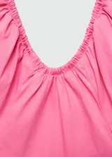 Vestido corto rosado con escote halter, espalda descubierta, falda acampanada y cierre lateral con cremallera.