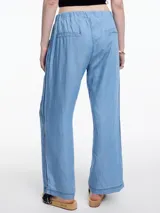 Pantalón celeste de pierna recta y calce relajado, confeccionado en denim 100% lyocell con cintura elástica, bolsillos laterales y pespuntes en color contraste.