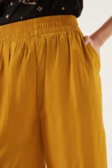 Pantalón crop color mostaza, de corte ancho y tiro alto, con cintura elastizada.