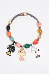 Collar con cordón trenzado multicolor, cuentas de colores y dijes colgantes con forma de peces en negro, blanco y dorado con detalles en rosa.