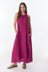 Vestido largo blanco de lino, sin mangas y con bolsillos laterales.