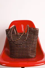 Bolso tipo tote de cuero marrón oscuro con diseño tejido.