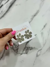 Par de aros con forma de flor color gris topo y centro con una perla.