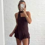 Vestido corto marrón con escote halter y falda con volados.