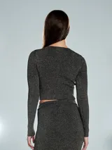 Buzo crop top dorado con textura acanalada y mangas largas.