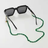 Correa para lentes de acrílico verde con eslabones pequeños y terminales dorados.