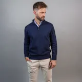 Buzo de punto color azul marino, con cuello alto y medio cierre frontal.