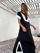 Vestido largo negro con paneles blancos en escote, mangas y ruedo.