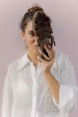 Sandalias de cuero marrón con tiras entrecruzadas y hebilla dorada al tobillo.