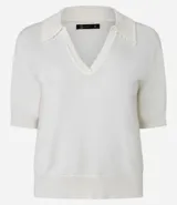 Blusa de punto color blanco, con cuello polo, escote en V y mangas cortas. Detalle de mini perlas aplicadas en el cuello.