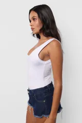 Body blanco al cuerpo de microfibra pesada, con escote cuadrado y espalda baja. Terminaciones en collareta. Para facilitar acceso, broches snap en entrepierna y elástico interno en contorno de tiro para mejor ajuste de la prenda al cuerpo.